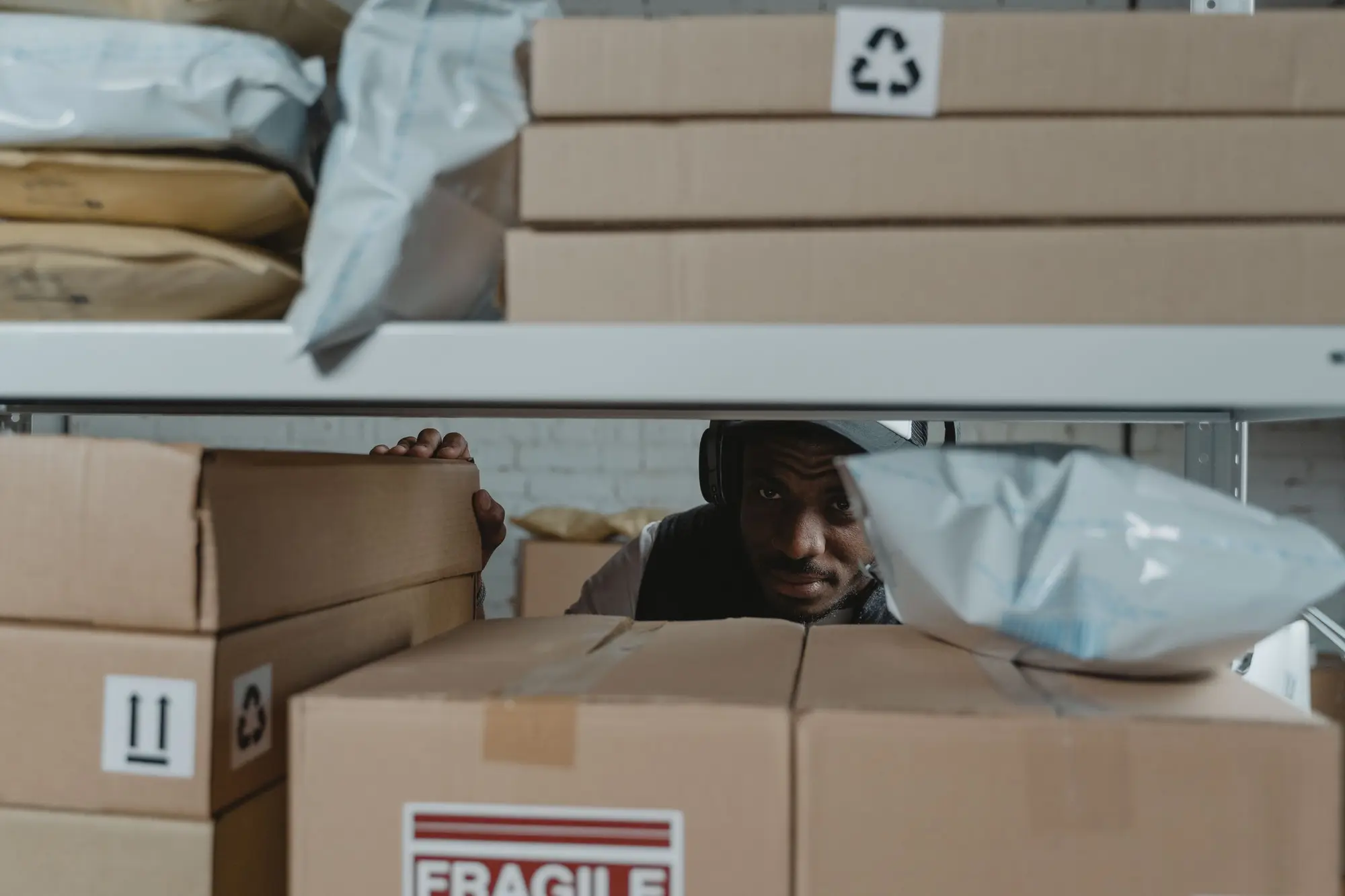 Person inspecting parcels on warehouse shelves