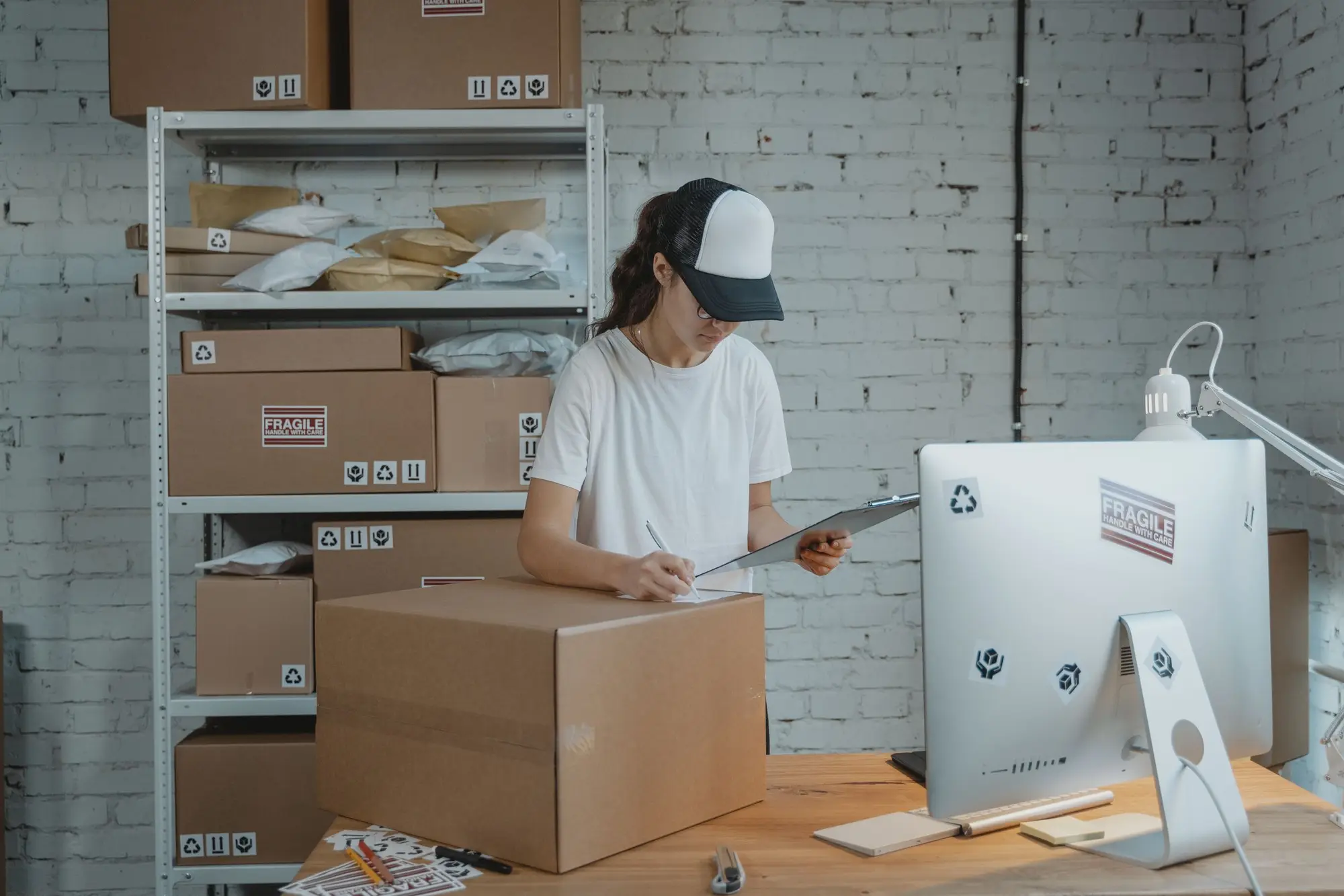 Person checking a clipboard beside shipping cartons